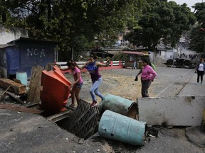 Roadblocks set up by anti-government protesters block a street in the Cotiza neighborhood during clashes with security forces as some residents show support for a mutiny by a National Guard unit in Caracas, Venezuela, Monday, Jan. 21, 2019. Venezuela's government said Monday it put down the mutiny.