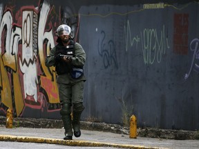 A Venezuelan Bolivarian National Guardsmen keeps an eye out for anti-government protesters after a rally demanding the resignation of President Nicolas Maduro, in Caracas, Venezuela, Wednesday, Jan. 23, 2019.  The head of Venezuela's opposition-run congress declared himself interim president at the rally, until new elections can be called.