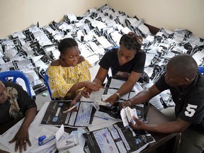 Congolese independent electoral commission (CENI) officials count the presidential ballots from over 900 polling stations at a local results compilation center in Kinshasa, Congo, Friday Jan. 4, 2019. CENI said Thursday the results from 20% of the polling stations have been collected.