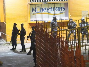Congolese riot police take position around the electoral commission building at night in Kinshasa, Congo, Tuesday Jan. 8, 2019. As Congo anxiously awaits the outcome of the presidential election, many in the capital say they are convinced that the opposition won and that the delay in announcing results is allowing manipulation in favor of the ruling party.