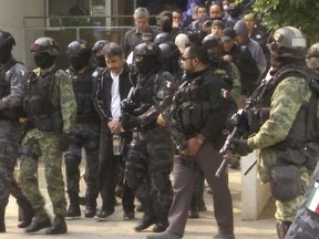 FILE - In this May 2, 2017 file photo, Damaso Lopez, a leader in Mexico's Sinaloa drug cartel, is escorted by police after his capture at an upscale apartment building in Mexico City. Lopez testified Wednesday, Jan. 23, 2019, at the U.S. trial of the Mexican drug lord known as El Chapo, implicating the kingpin's wife in his 2015 prison escape.