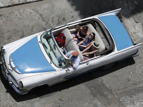 FILE - In this May 13, 2015, file photo, tourists ride a classic American convertible in Havana, Cuba. President Donald Trump's Cuba policy is driving hundreds of millions of dollars from the island's private entrepreneurs to its military-controlled tourism sector, the opposite of its supposed goal, new statistics say.