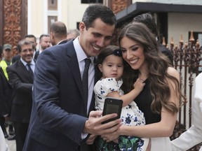 FILE - In this Jan. 5, 2019 file photo, incoming congressional president Juan Guaido, left, takes a selfie photo with his wife Fabiana Rosales and his daughter Miranda Guaido upon arrival to swear in the new board of the National Assembly in Caracas, Venezuela. Guaido stunned Venezuelans on Wednesday, Jan. 23, 2019 by declaring himself interim president before cheering supporters in Venezuela's capital, buoyed by massive anti-government protests.
