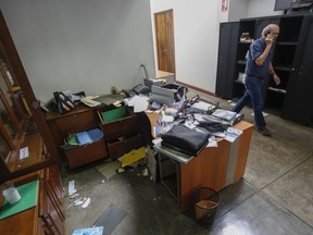 FILE - In this Dec. 14, 2018 file photo, Confidencial director Carlos Fernando Chamorro, son of former President Violeta Barrios de Chamorro, walks through his ransacked offices while talking on his cellphone in Managua, Nicaragua. The prominent Nicaraguan journalist announced in a video posted to his Confidencial Facebook page on Monday, Jan. 21, 2019 that he had taken "the painful decision to go into exile to ensure my freedom and physical safety, and above all to carry on independent journalism from Costa Rica."