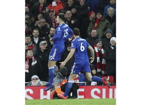 Leicester City defender Harry Maguire, celebrates with his teammate Jonny Evans after scoring his side opening goal, during the English Premier League soccer match between Liverpool and Leicester City, at Anfield Stadium, Liverpool, England, Wednesday, Jan.29, 2019. In foreground is Liverpool forward Mohamed Salah.