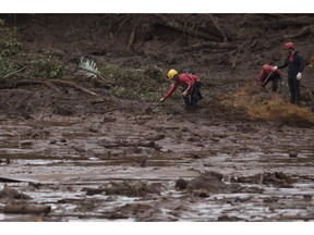 Firefighters search tin he mud, after a dam collapse near Brumadinho, Brazil, Saturday, Jan. 26, 2019. Rescuers in helicopters on Saturday searched for survivors while firefighters dug through mud in a huge area in southeastern Brazil buried by the collapse of a dam holding back mine waste, with at least nine people dead and up to 300 missing.