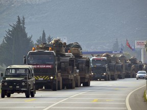 A convoy of Turkish military trucks carrying tanks and armoured personnel carriers destined for Syria in preparation for a possible military offensive, moves in Hatay province, southeastern Turkey, near the border with Syria, Monday, Jan. 14, 2019. U.S. Secretary of State Mike Pompeo said Monday that U.S. President Donald Trump's threat to devastate NATO ally Turkey's economy if it attacks U.S.-backed Kurdish fighters in Syria underscores America's commitment to its partners. (Mehmet Kocacik/Kirikhan/DHA via AP)