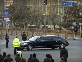Security officials stand guard while a Mercedes limousine in a motorcade believed to be carrying North Korean leader Kim Jong Un passes along a street in Beijing, Wednesday, Jan. 9, 2019. North Korean state media reported Tuesday that Kim is making a four-day trip to China in what's likely an effort by him to coordinate with his only major ally ahead of a summit with U.S. President Donald Trump that could happen early this year.