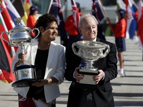 Australian tennis legends Evonne Goolagong Cawley and Rod Laver hold the women's and men's trophies, the Daphne Akhurst Memorial Cup and the Norman Brookes Challenge Cup at the official start of the Australian Open tennis championships in Melbourne, Australia, Monday, Jan. 14, 2019.
