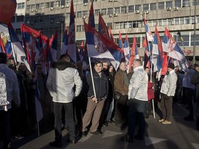 Supporters of Russia's president Vladimir Putin and his Serbian counterpart Aleksandar Vucic hold Serbian flags during a gathering in Belgrade, Serbia, Thursday, Jan. 17, 2019.  Amid a lavish welcome, Putin arrived in Serbia on Thursday in a show of the Russian president's support for the Balkan country's populist leader and his pro-Moscow policies.