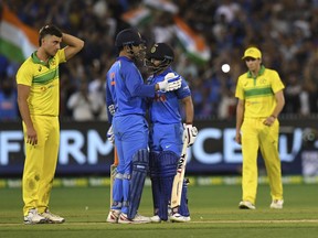 India's M.S. Dhoni and Kedar Jadhav embrace during their one day international cricket match against Australia in Melbourne, Australia, Friday, Jan. 18, 2019.