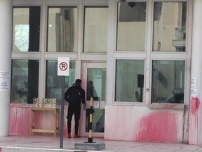 A man stands at an entrance of the US embassy in Greece, some hours after an anarchist group threw red paint, in Athens, on Monday, Jan. 7, 2019. Police said Monday that eight were detained after about 10 people on motorbikes threw red paint at the embassy's parking entrance at around 3:30 a.m. local time. An anarchist group known as Rouvikonas claimed responsibility for the attack in an internet post.