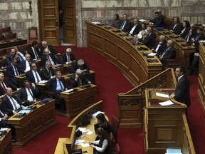 Greek Prime Minister Alexis Tsipras, right, speaks during a parliamentary session in Athens, on Tuesday, Jan. 15, 2019. Greece's prime minister is defending his deal to normalize relations with neighboring Macedonia ahead of a confidence vote in parliament after his governing coalition collapsed over the agreement.