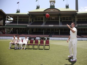 Australia's Mitch Marsh, right, catches a football as the Australian cricket team prepare to pose for a photo before a training session in Sydney, Wednesday, Jan. 2, 2019, ahead of their cricket test match against India starting Jan. 3.