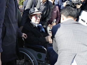 FILE - In this Oct. 30, 2018, file photo, South Korean Lee Chun-sik, 94-year-old victim of forced labor during Japan's colonial rule of the Korean Peninsula before the end of World War II, sits on a wheelchair upon his arrival at the Supreme Court in Seoul, South Korea. Lawyers for South Koreans forced into wartime labor have taken legal steps to seize the South Korean assets of a Japanese company they are trying to pressure into following a court ruling to provide them compensation.