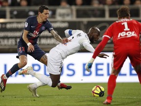 PSG's Angel Di Maria, left, and Amiens' Prince-Desir Gouano challenge for the ball during the French League One soccer match between Amiens and Paris-Saint-Germain at the Stade de la Licorne stadium in Amiens, France, Saturday, Jan. 12, 2019.