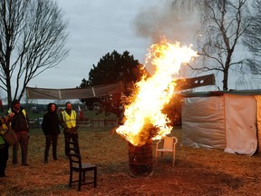 Protestors wearing yellow vests stand next to a fire in a makeshift camp on a roundabout near Senlis, north of Paris, Thursday, Jan. 10, 2019. With its makeshift grocery, camp beds and community spirit, the large central island about 60 kilometers north of Paris has been transformed over the past two months into an encampment where dozens of yellow vests protesters gather day in day out to organize their long-standing fight against the French government.