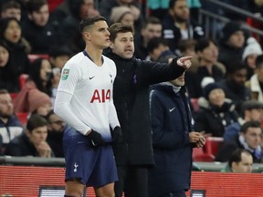 Tottenham's coach Mauricio Pochettino, right, talks to Tottenham's Erik Lamela during the English League Cup semifinal first leg soccer match between Tottenham Hotspur and Chelsea at Wembley Stadium in London, Tuesday, Jan. 8, 2019.