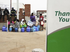 People wait in a queue for cooking gas at a garage in the capital Harare, Wednesday, Jan, 23, 2019. The Southern African nation remained tense as President Emmerson Mnangagwa's call for national dialogue is met with skepticism, and reports of abuses by security forces continued.
