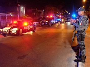 A Federal police officer stands on guard at the area where at least five people including a ministerial police officer were killed in Puerto Juarez, Cancun, Quintana Roo State, Mexico, on July 27, 2018.