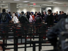 Travellers stand in line to enter a Transportation Security Administration (TSA) check-point at Hartsfield-Jackson Atlanta International Airport in Atlanta, Georgia, U.S., on Monday, Jan. 14, 2019.