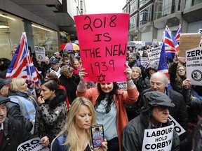 People hold up placards at a demonstration organized by the Campaign Against Anti-Semitism outside the head office of the British Labour Party in central London on April 8, 2018.