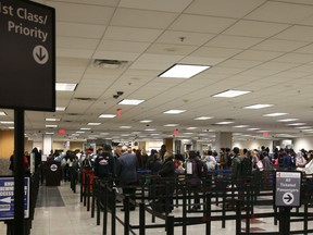 Travelers stand in line to enter a Transportation Security Administration (TSA) check-point at Hartsfield-Jackson Atlanta International Airport in Atlanta, Georgia, U.S., on Monday, Jan. 14, 2019.