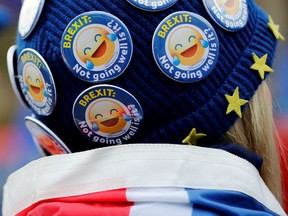 An anti-Brexit activist wears a hat covered in badges reading "Brexit: Not going well is it?" as she demonstrates opposite the Houses of Parliament in London on January 29, 2019. - British Prime Minister Theresa May heads into her latest Brexit battle on Tuesday weakened but still determined to get her legacy-defining deal through parliament, as MPs wrestle to take control of the process.