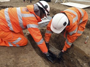 An image taken on Jan. 18, 2019 and issued by HS2 shows archeologists removing the lead plate placed on top of the coffin of Captain Matthew Flinders at the archaeological excavation and research works at St James's Gardens in Euston, London.