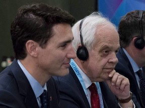 In this Nov. 14, 2018 photo, Canada's Ambassador to China John McCallum sits next to Prime Minister Justin Trudeau, left, during a bilateral meeting with Chinese Premier Li Keqiang in Singapore.