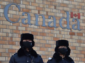 Chinese police officers patrol outside the Canadian embassy in Beijing.