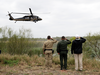 President Donald Trump salutes as a U.S. customs and Border Protection helicopter passes as he tours the U.S. border with Mexico at the Rio Grande on the southern border, Jan. 10, 2019, in McAllen, Texas.
