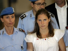 In this Tuesday Sept. 16, 2008 file photo, Amanda Knox, centre, is escorted by Italian penitentiary police officers from Perugia's court after a hearing, central Italy.