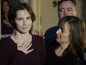 In this Friday, March 27, 2015 file photo, Amanda Knox, left, talks to reporters as her mother, Edda Mellas, right, looks on outside Mellas' home in Seattle. Europe's human rights court has ordered Italy to pay Amanda Knox around 18,000 euros ($20,000) in financial damages for police failure to provide legal assistance and a translator during questioning following the Nov. 1, 2007 killing of her British roommate.