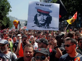 A man holds a banner with a picture of revolutionary leader Che Guevara during a demonstration against reforms to France's debt-laden state rail operator that some unions opposed, in Paris on June 28, 2018.