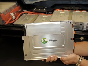 A lithium-ion battery cell is displayed in front of  Nissan Motors' second generation EV near Tokyo on July 27, 2009.