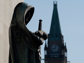 Veritas (Truth) guards the entrance of the Supreme Court of Canada as the Peace tower is seen in the background in an April 25, 2014, file photo from Parliament Hill.