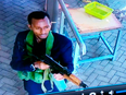 An armed attacker walks in the compound of a hotel, in Nairobi, Kenya, on Jan. 15, 2019. The Somalia-based terror group Al-Shabab claimed responsibility.