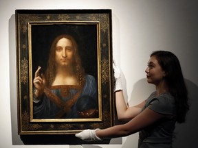 A Christie's employee poses with Salvator Mundi, a painting attributed to Leonardo da Vinci, on Oct. 24, 2017.