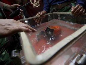 The newly recovered cockpit voice recorder of Lion Air flight 610 is kept in a water-filled container on board of Indonesian Navy ship KRI Spica in the waters of Tanjung Karawang, Indonesia, Monday, Jan. 14, 2019. Navy divers recovered the cockpit voice recorder of the Lion Air jet that crashed into the Java Sea in October in a possible boost to the accident investigation.