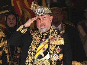 In this July 17, 2018, file photo, Malaysian King Sultan Muhammad V salutes during the national anthem at the opening of the 14th parliament session at the Parliament house in Kuala Lumpur, Malaysia.