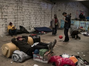 A migrant from Honduras rests on top of his belongings inside an empty warehouse used as a shelter set up for migrants in downtown Tijuana, before been relocated to other shelters in Tijuana, Mexico, Friday, Jan. 4, 2019.