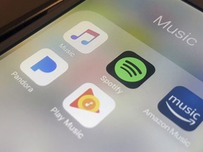 This Sunday, Jan. 28, 2018, photo shows music streaming apps clockwise from top left, Apple, Spotify, Amazon, Pandora and Google on an iPhone in New York.