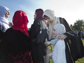 A Muslim girl arranges her sister's hijab as they arrive for Eid al-Adha prayers, Friday, Sept. 1, 2017 in Bensonhurst Park in the Brooklyn borough of New York. Muslims worldwide are celebrating Eid al-Adha, or the Feast of the Sacrifice, which commemorates the biblical story of Abraham and his readiness to sacrifice his son as an act of obedience to God.