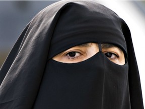 A woman wears a niqab as she walks Monday, September 9, 2013 in Montreal. The Quebec government is scheduled to release more details of its proposed Charter of Quebec Values Tuesday, Sept. 10, 2013.