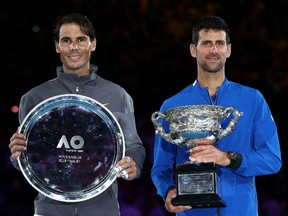 Novak Djokovic of Serbia poses with the Norman Brookes Challenge Cup following victory in his Men's Singles Final match along side runner up Rafael Nadal of Spain during day 14 of the 2019 Australian Open at Melbourne Park on January 27, 2019 in Melbourne, Australia.