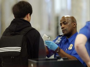 A Transportation Security Administration employee checks an air traveler's identification at Hartsfield Jackson Atlanta International Airport Monday, Jan. 7, 2019, in Atlanta.