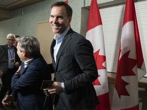 Finance Minister Bill Morneau jokes with Infrastructure and Communities Minister Francois-Philippe Champagne as he arrives for a cabinet meeting in Sherbrooke, Que., Wednesday, Jan. 16, 2019.