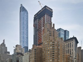 In this May 26, 2016 file photo, a crane sits atop ongoing construction for a new condominium skyscraper at 220 Central Park South in New York.