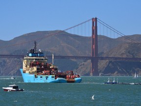 In this Sept. 8, 2018 file photo, a ship tows The Ocean Cleanup's first buoyant trash-collecting device toward the Golden Gate Bridge in San Francisco en route to the Pacific Ocean. A trash collection device deployed to corral plastic litter floating between California and Hawaii will be hauled back to dry land for repairs. Boyan Slat, who launched the Pacific Ocean cleanup project, tells NBC the 2,000-foot (600-meter) long floating boom will be towed to Hawaii.